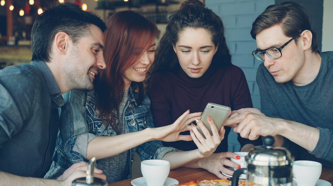 people using smartphones in cafe
